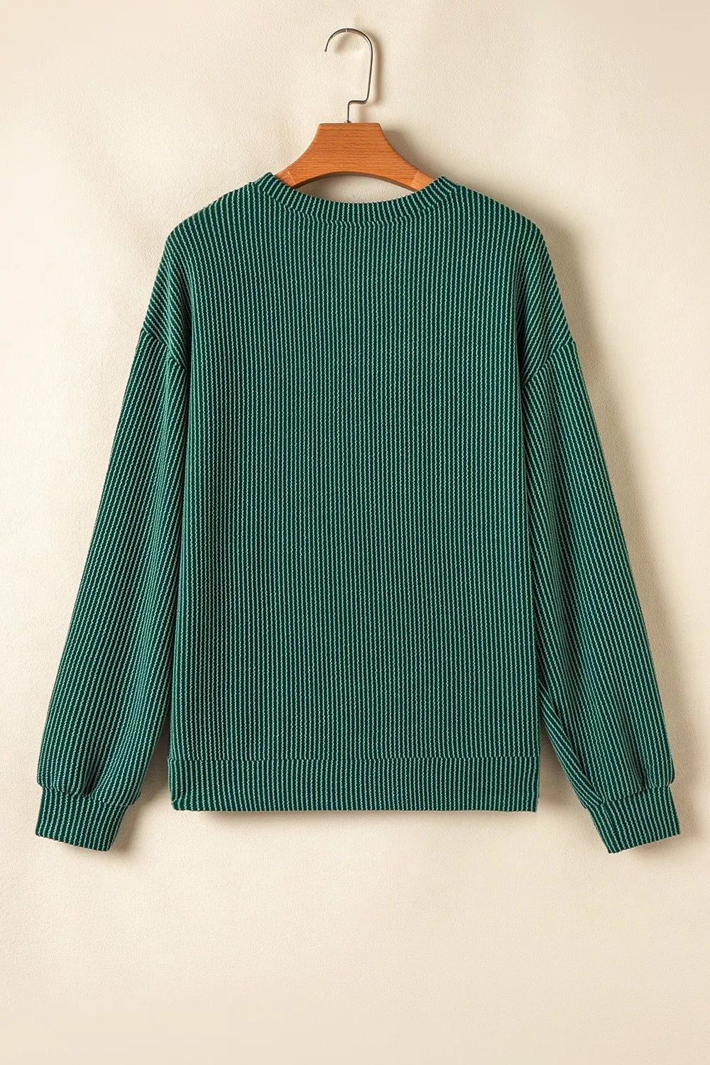 Green polyester top and drawstring pants set in Jolly Christmas style, hung on a wooden hanger.