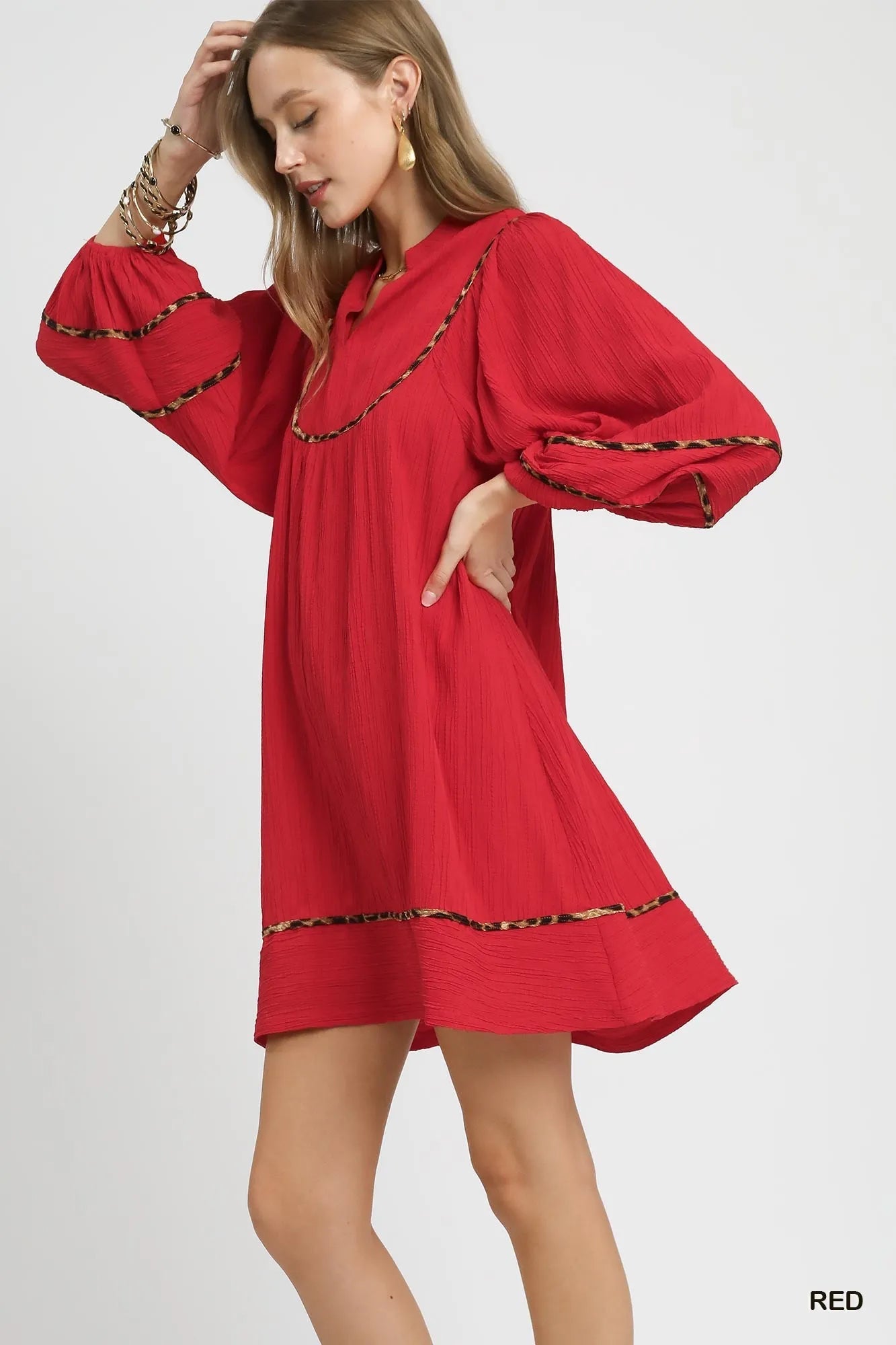 Red textured babydoll dress with leopard trim and puffed sleeves on model.