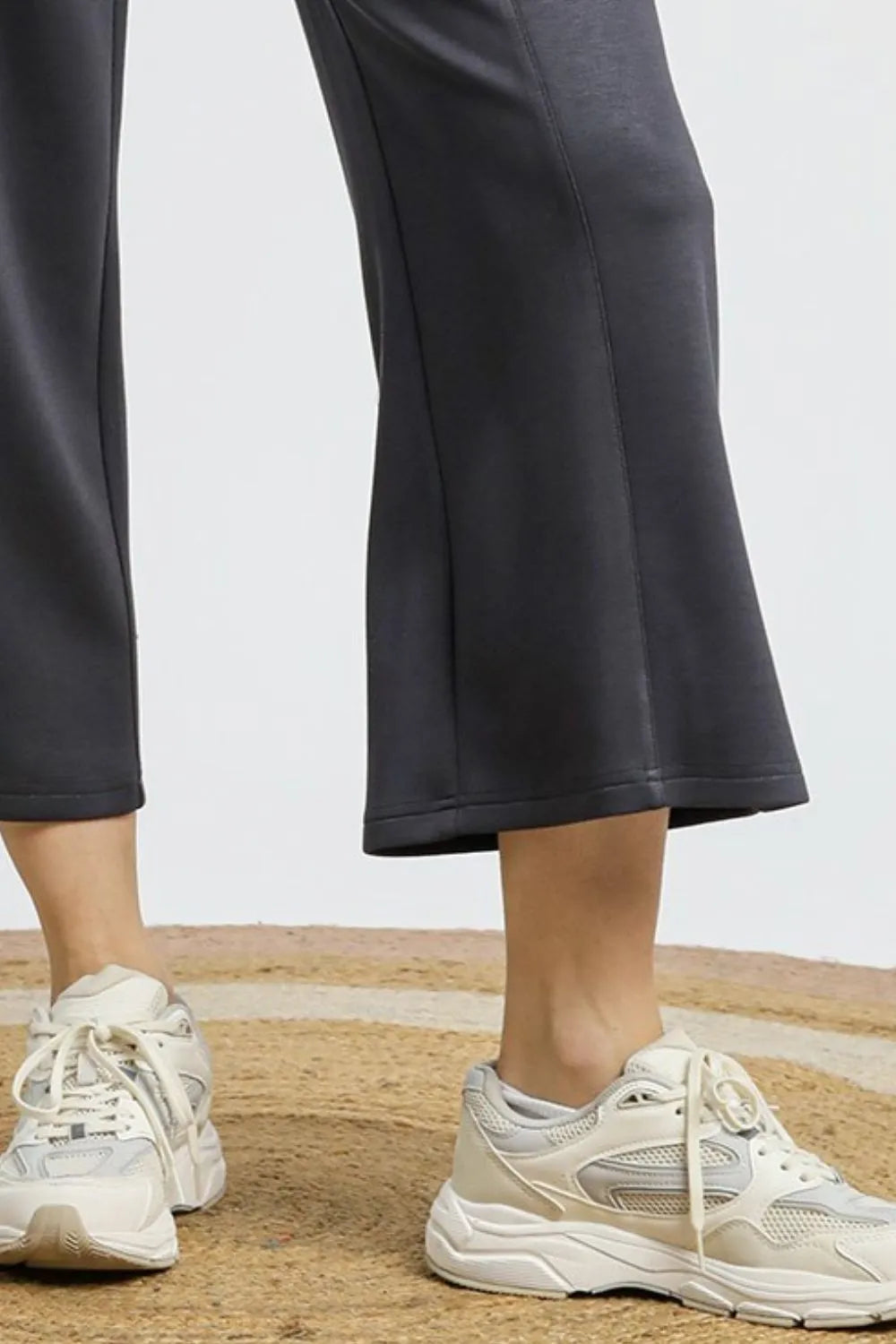 Charcoal gray drawstring wide-leg cropped pants on a model with white sneakers.